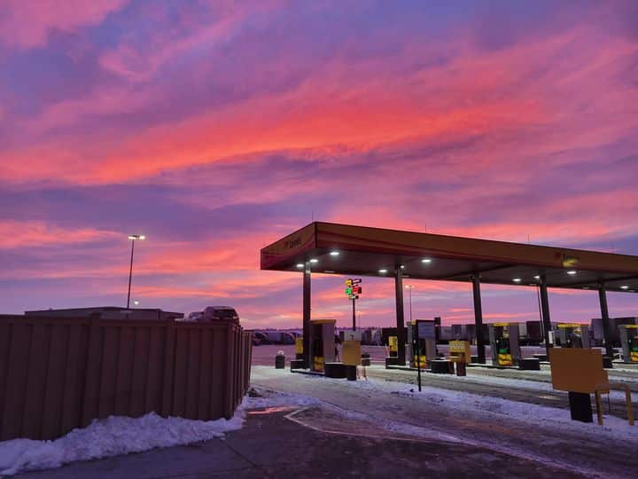 Two melton trucks backed into truck stop parking.