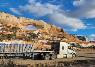 A silver Melton ambassador truck in front of Wilson's Arch in Utah