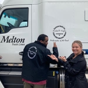 Million miler posing with their jacket and truck.