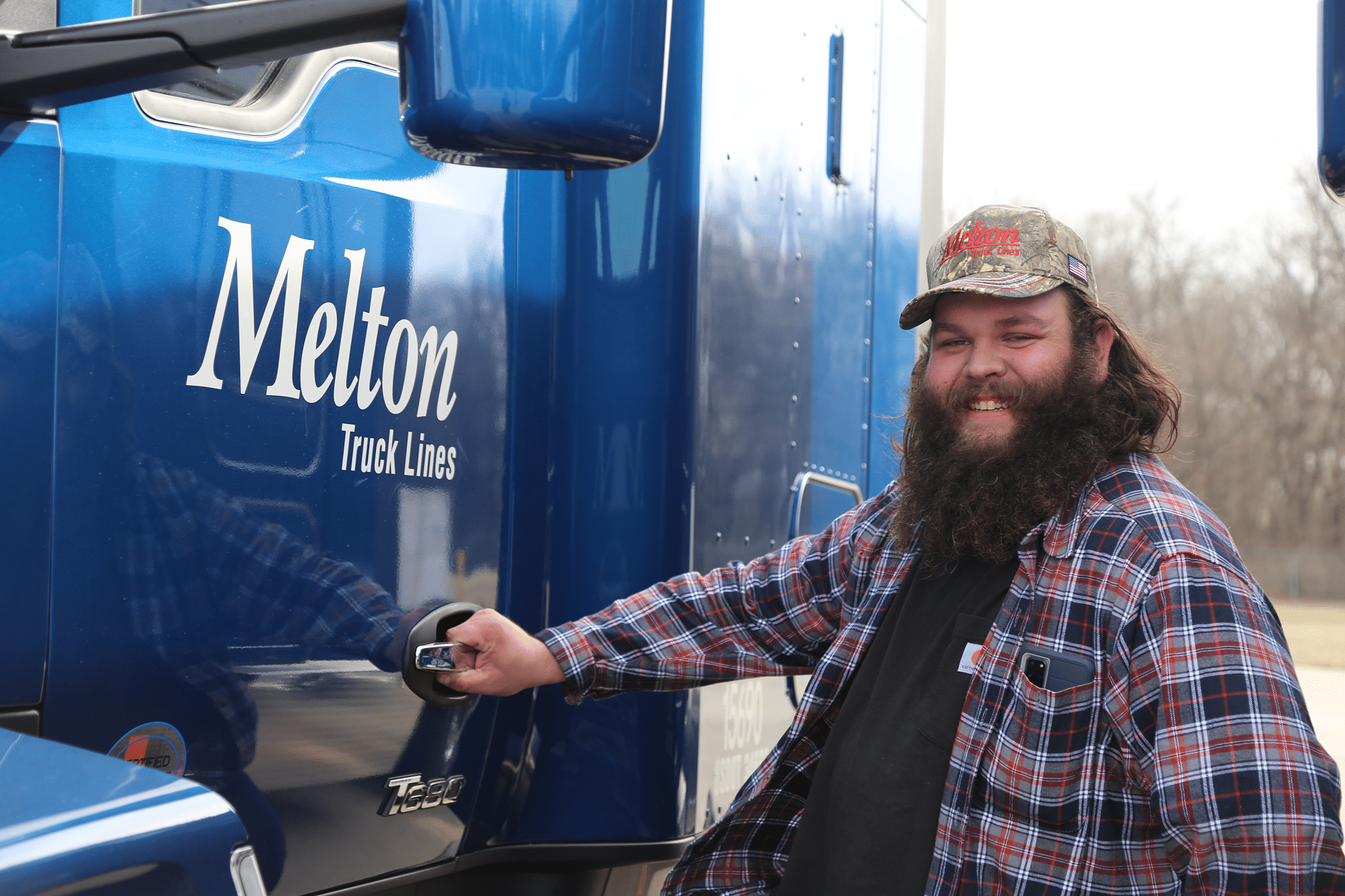 Two melton trucks backed into truck stop parking.