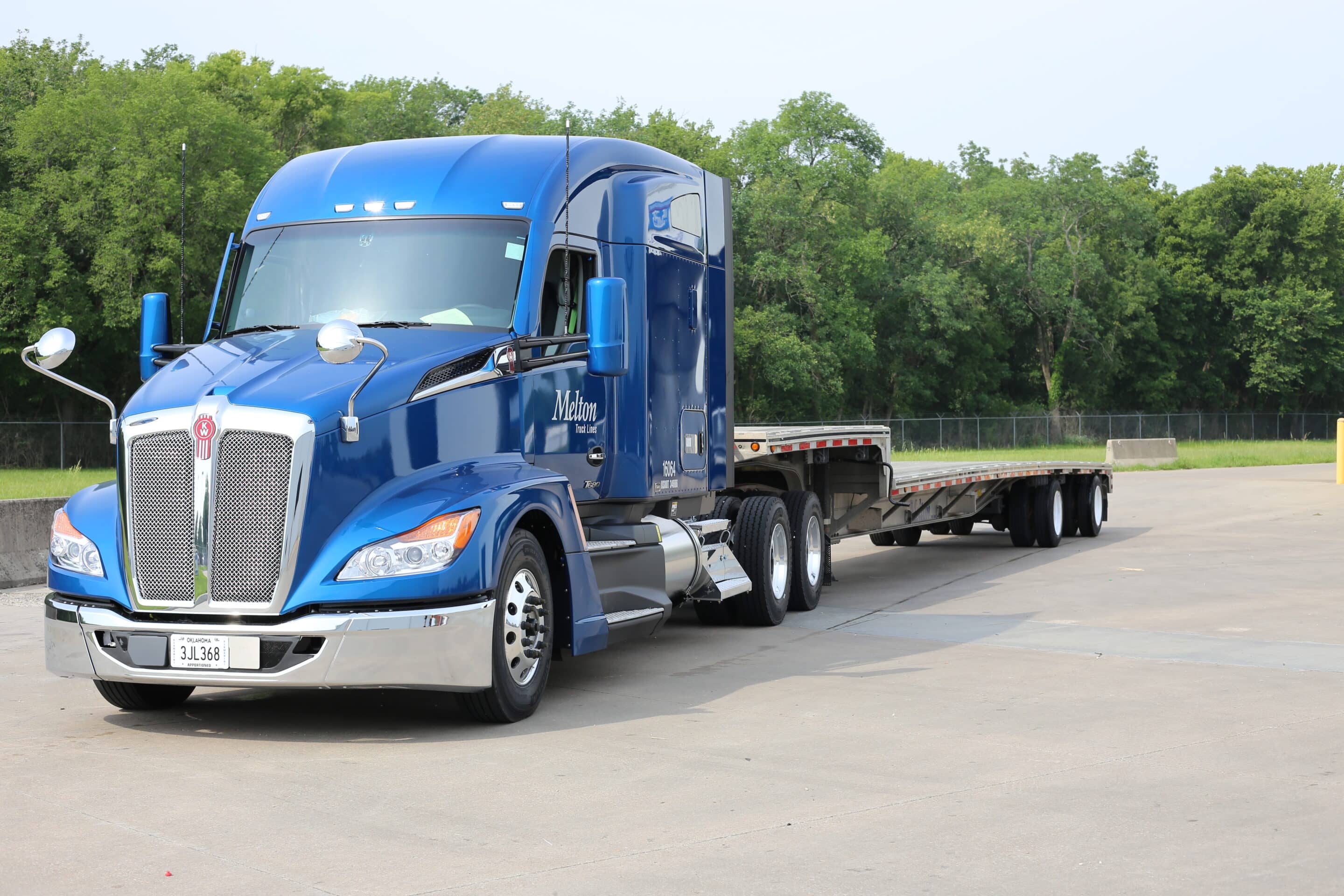 blue melton truck with step deck trailer