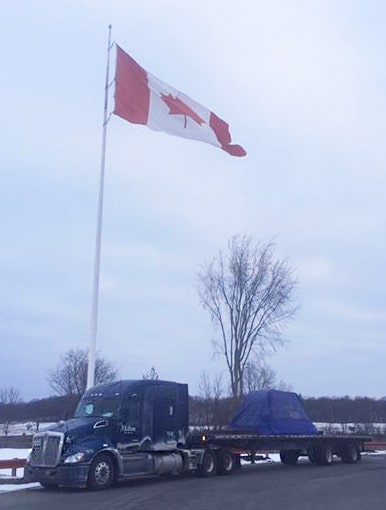 Melton flatbed Truck in front of a canada flag