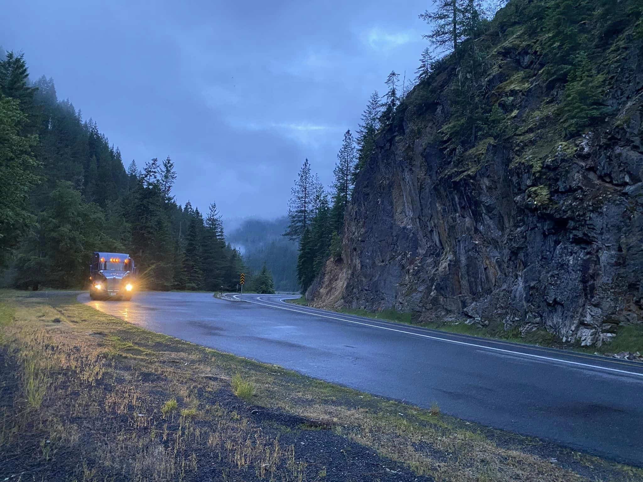 Melton truck driving through the mountains on a cloudy day.