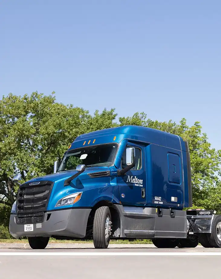 Blue flat bed truck with Melton logo parked.