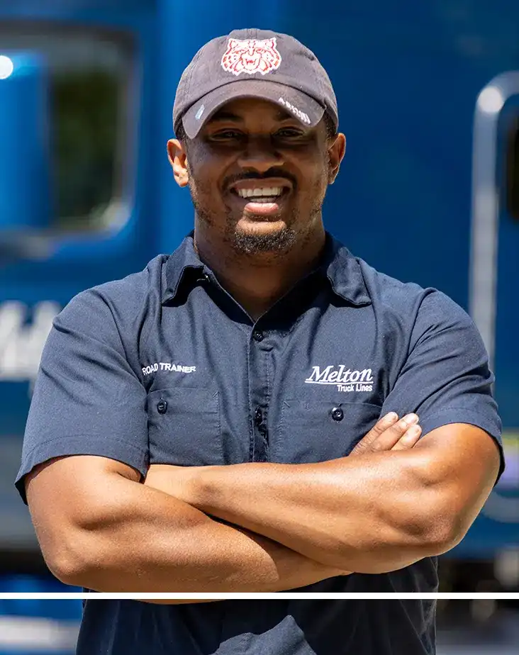 Flatbed trucking driver in front of a flatbed truck.