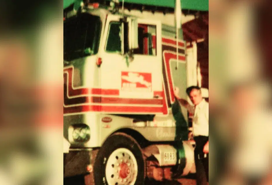 Old photo of a Melton driver standing next to a truck with the running rabbit logo