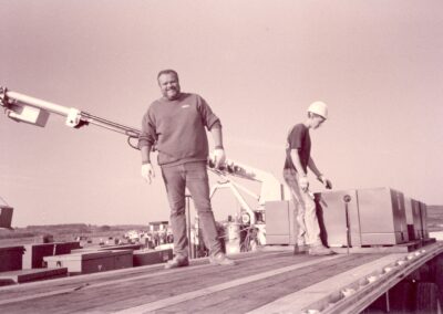 Black and white photo of two men working on a flatbed trailer