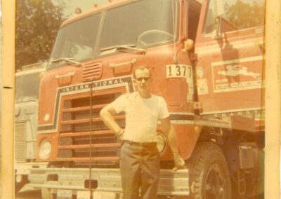 Old photo of a Melton driver standing in front of his truck