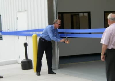 Melton CEO Bob Peterson cutting a blue ribbon
