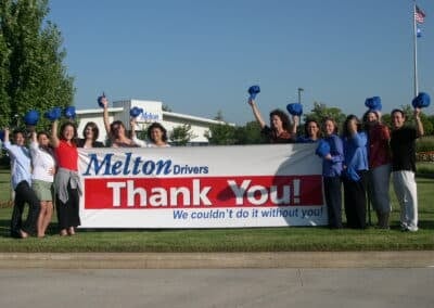 Melton Employees holding up a banner that says "Thank You:"