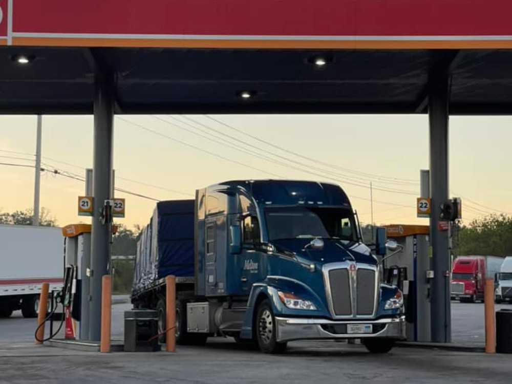 A Melton truck parked in  a fuel bay at a truck stop.