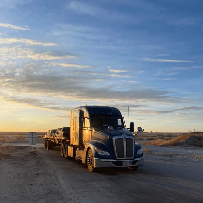 A Melton truck parked with a sunset in the background