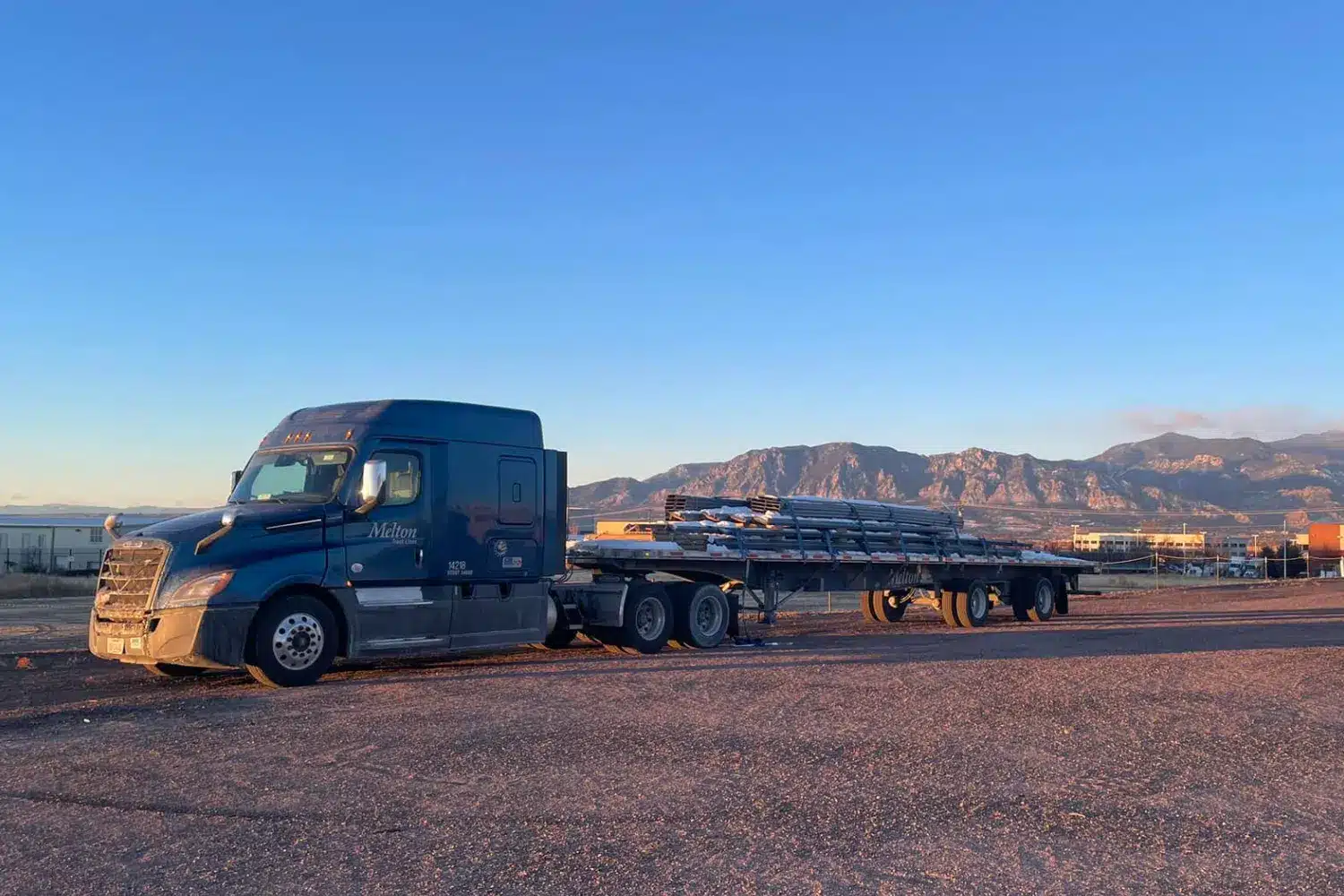 A Melton truck with a load parked in the sunset