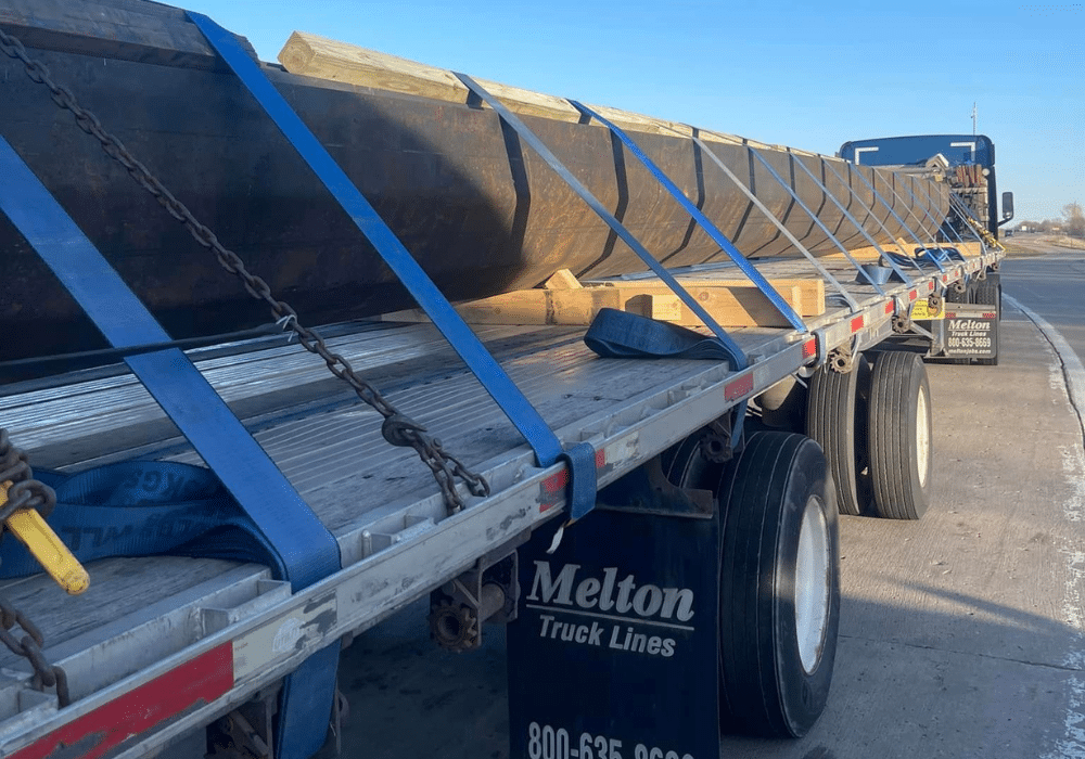Melton truck with a load secured by straps