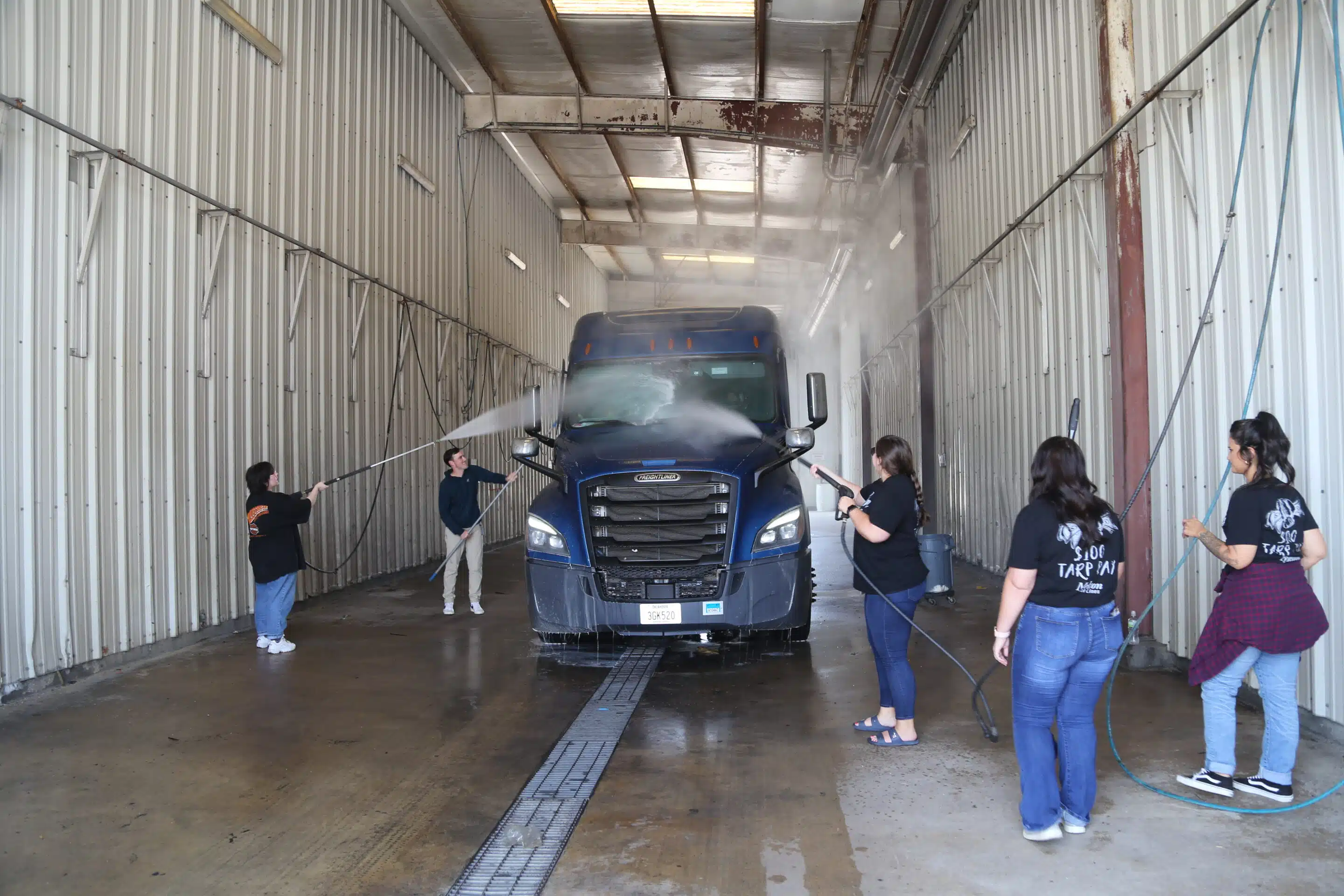 Melton employees washing a truck in the wash bay.