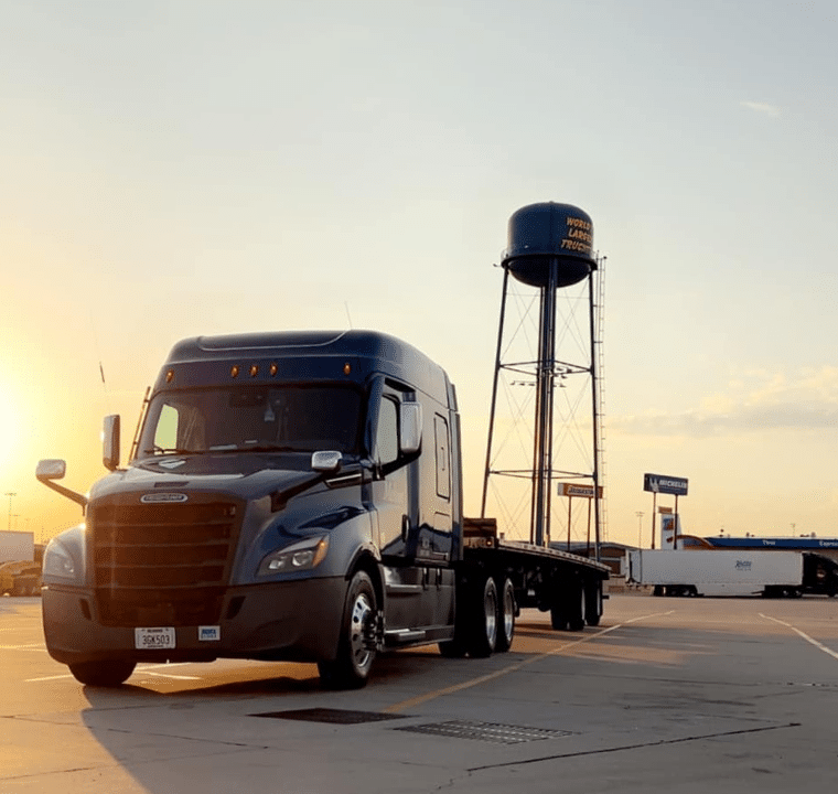 A Melton truck parked in front of a water tower