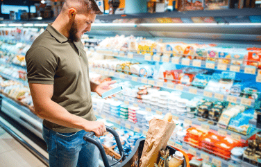 Man looking at a grocery list on his phone while at the store