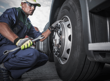 A mechanic working on the tire of a semi-truck