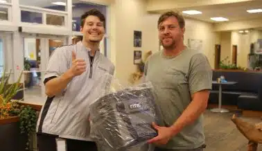 Melton driver and employee posing with a cooler prize from a Driver Appreciation Week giveaway.