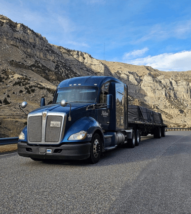 A Melton truck with a tarped load