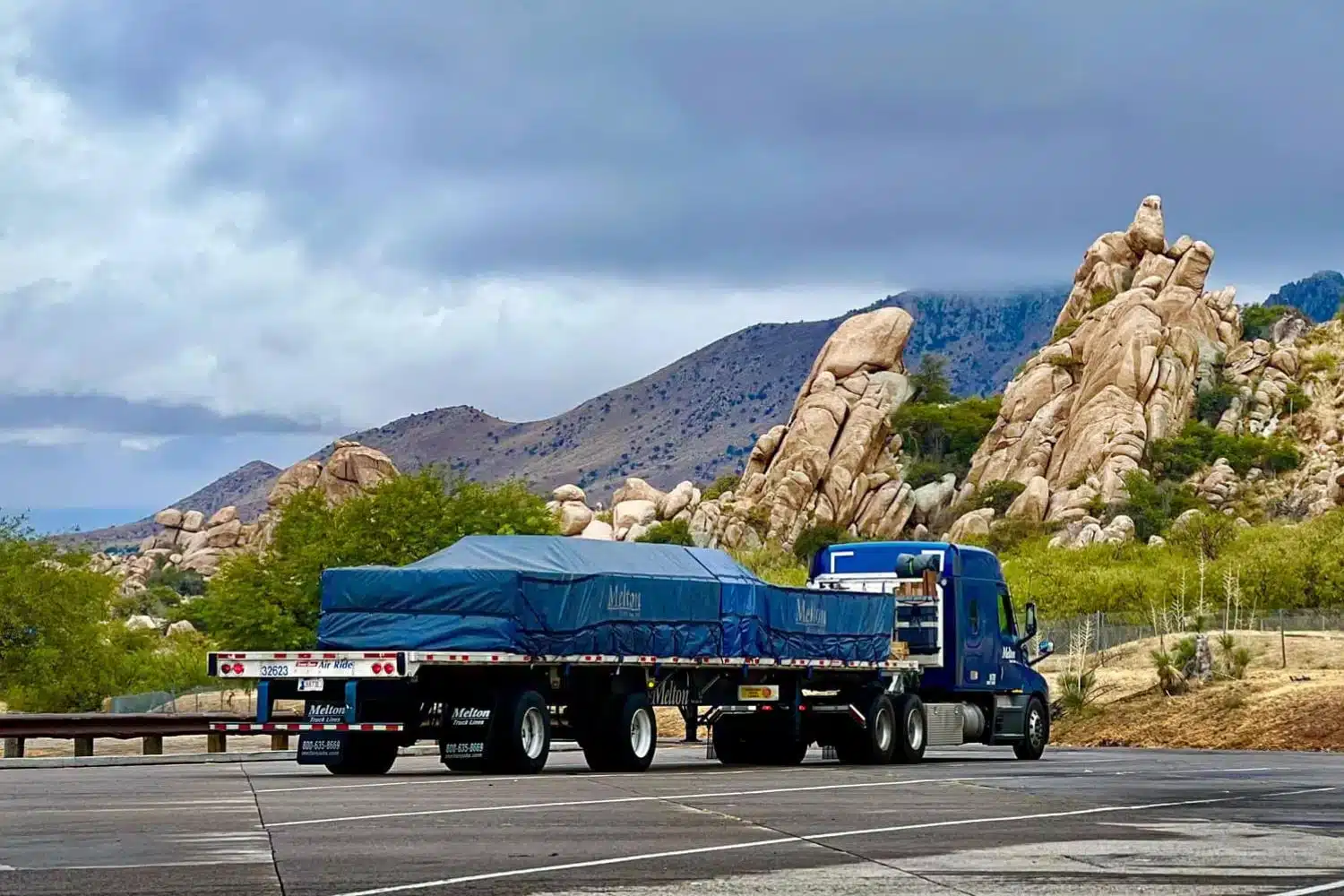 A Melton truck parked in front of some cliffs