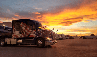 Melton truck with a patriotic wrap parked in the sunset