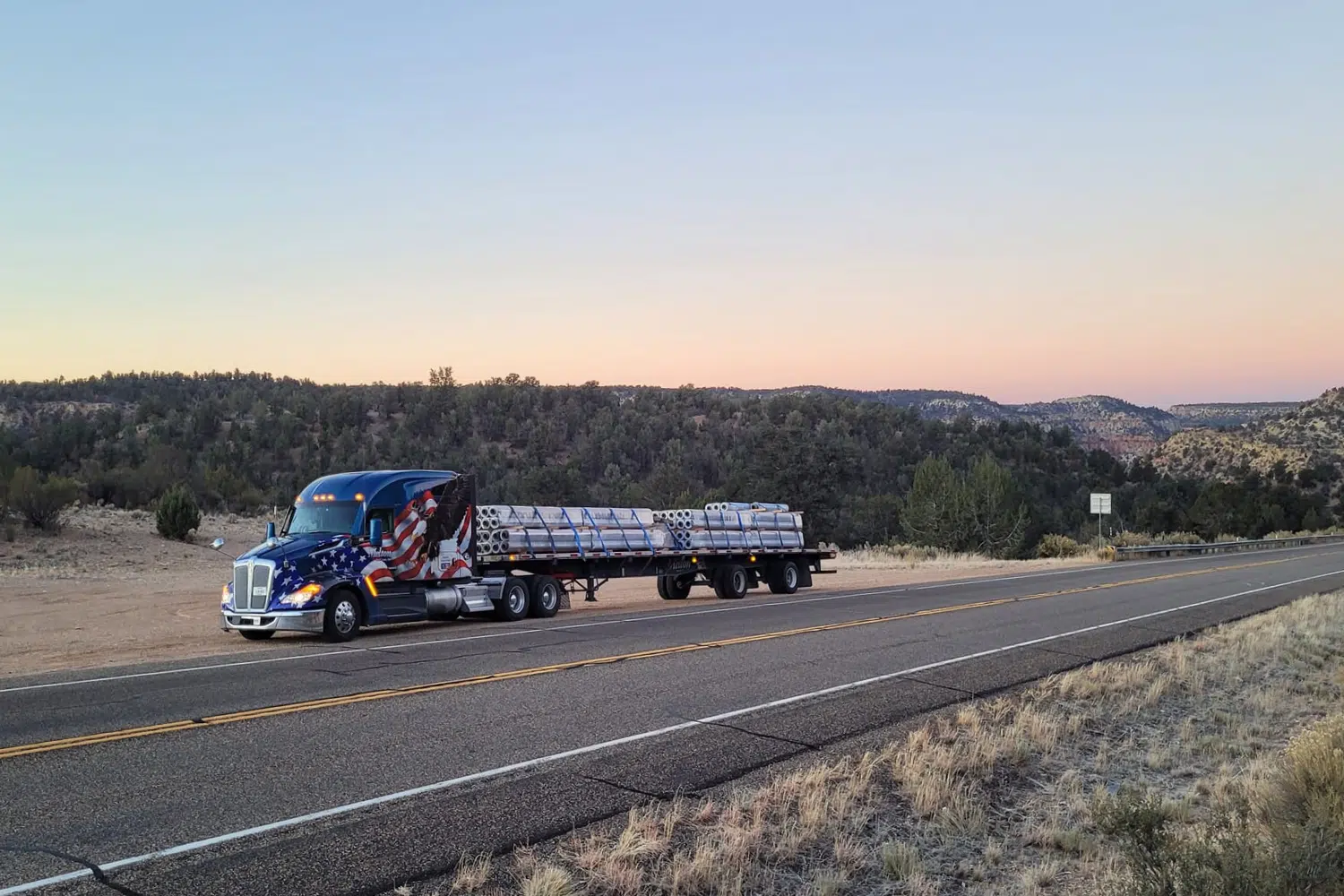 Melton truck with patriotic wrap parked on the side of the road in the sunset