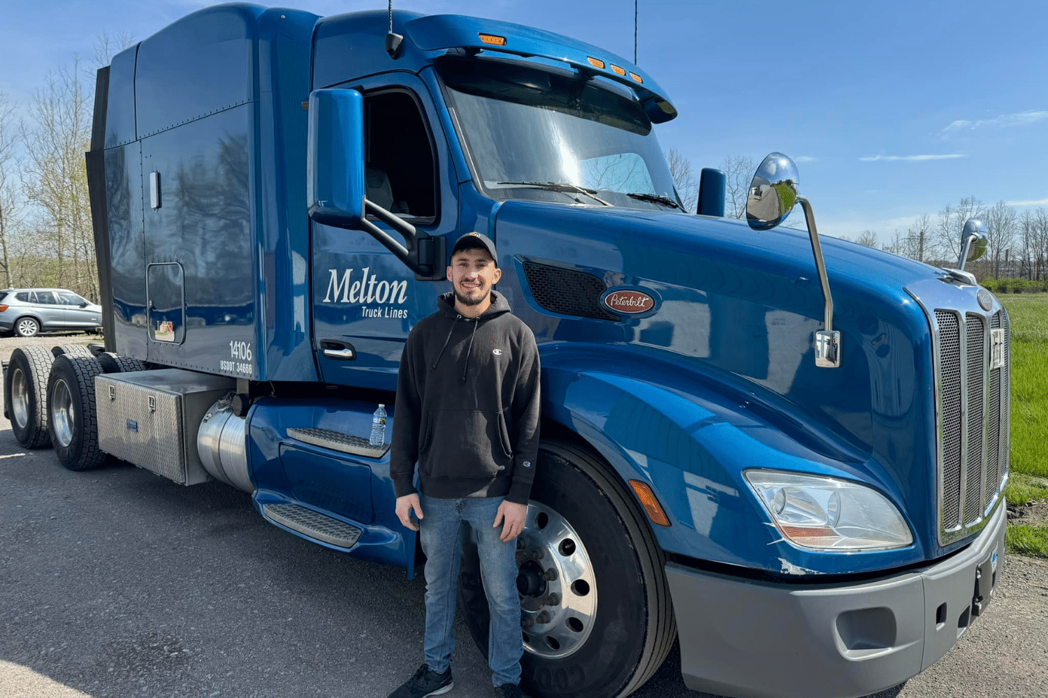 A new Melton driver standing in front of a blue Melton truck