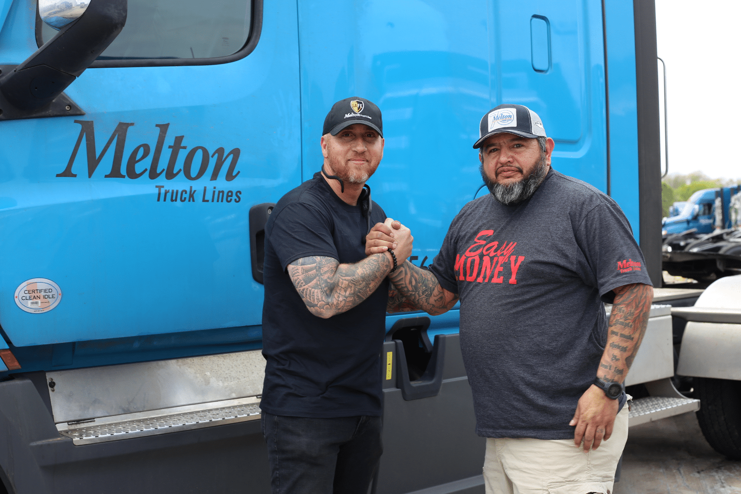 Two Melton drivers shaking hands in front of a truck