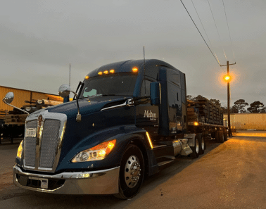 A Melton truck parked in a parking lot with a light behind it