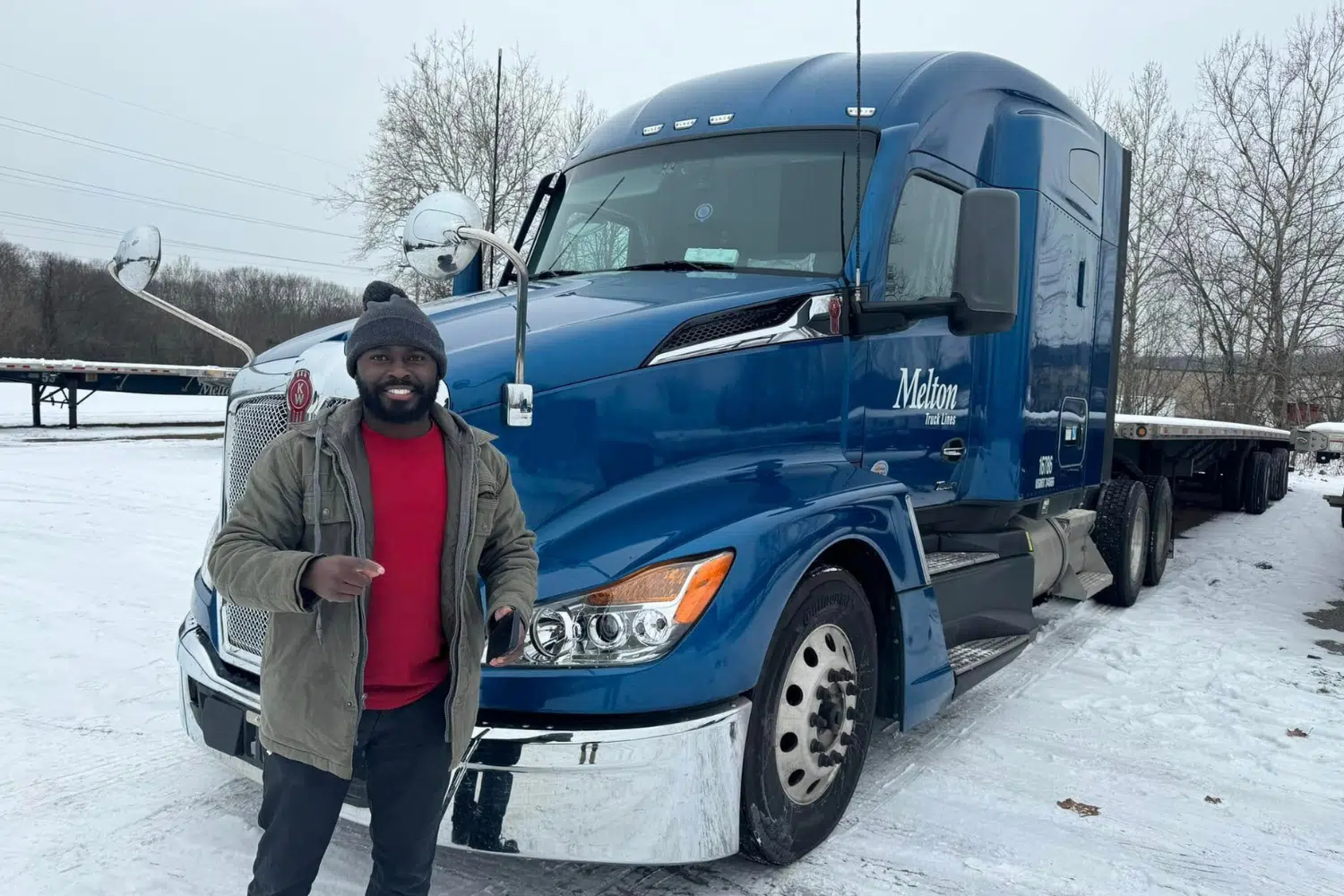 A Melton driver standing in front of his truck in the snow