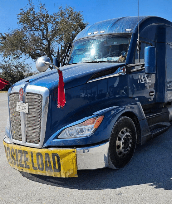 A Melton truck with an oversized banner and red flags