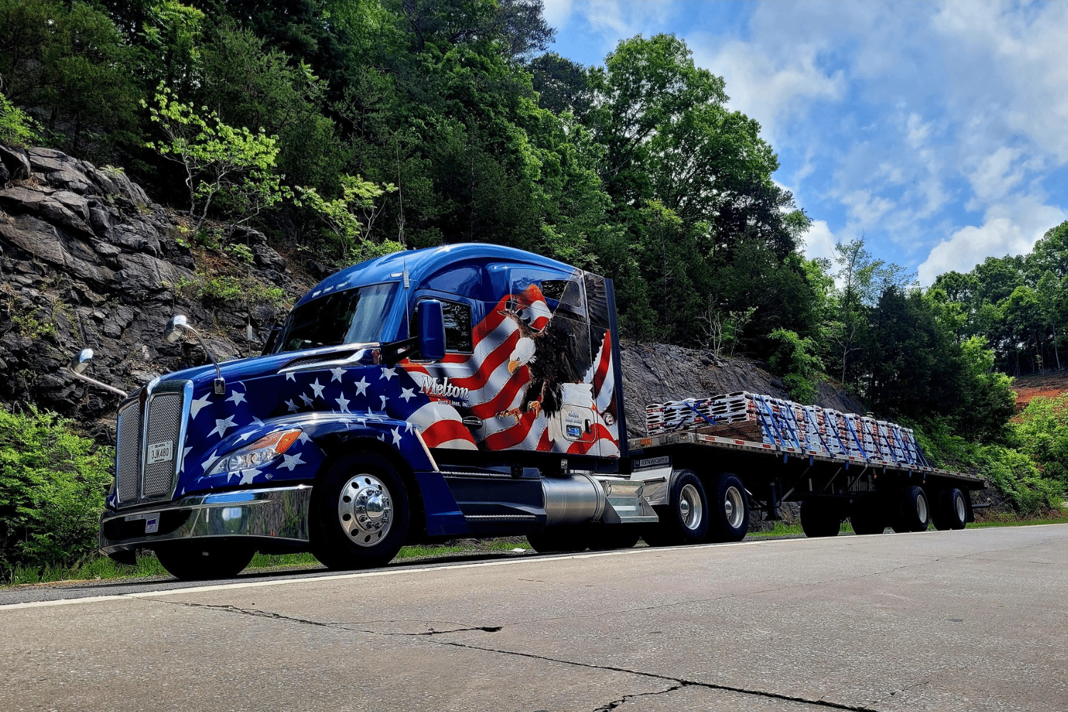 A Melton truck parked in front of some trees